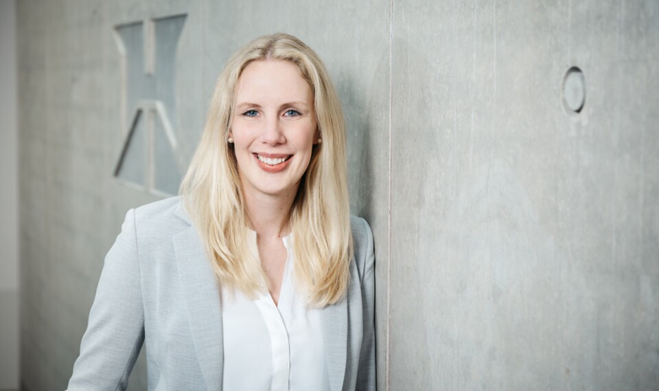 Frau lächelnd vor einer weißen Wand