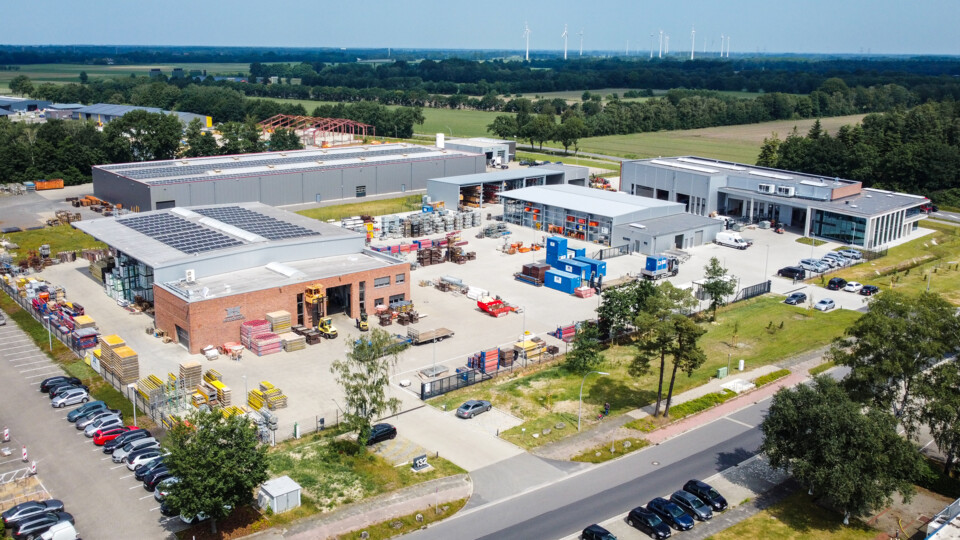 Blick von oben auf das Hofschröer Gebäude, das von Bäumen und Autos umgeben ist, in einer städtebaulichen Umgebung